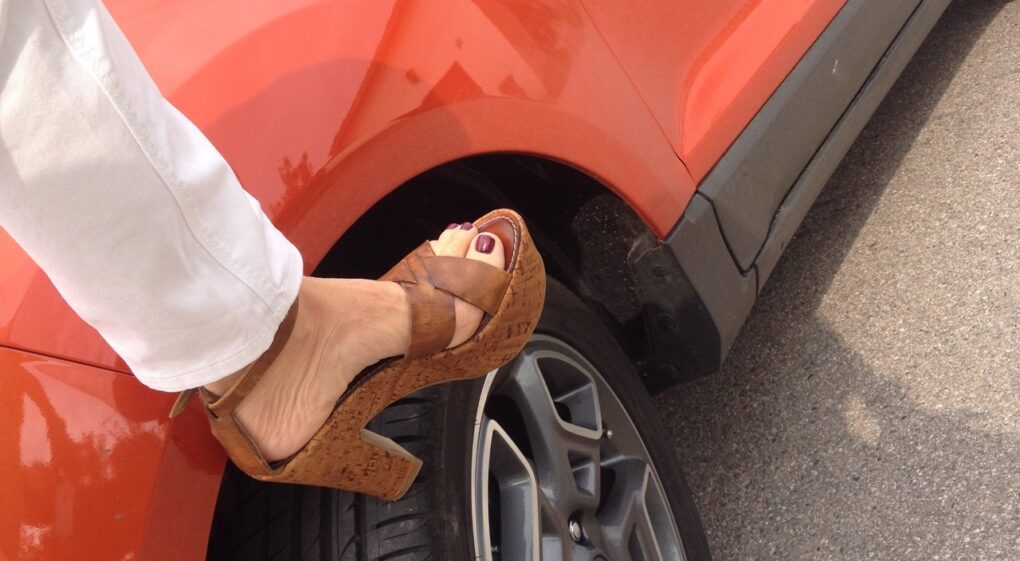 Höher gelegt mag Frau eben. Die braunen 12 cm-Plateausandalen passen gut zur 20 cm-Bodenfreiheit des mars-roten Ecosport.